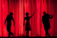 Actors sillouettes against a red curtain